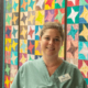 Stephanie Sprout, CNE, in front of a quilt at Royal Jubilee Hospital