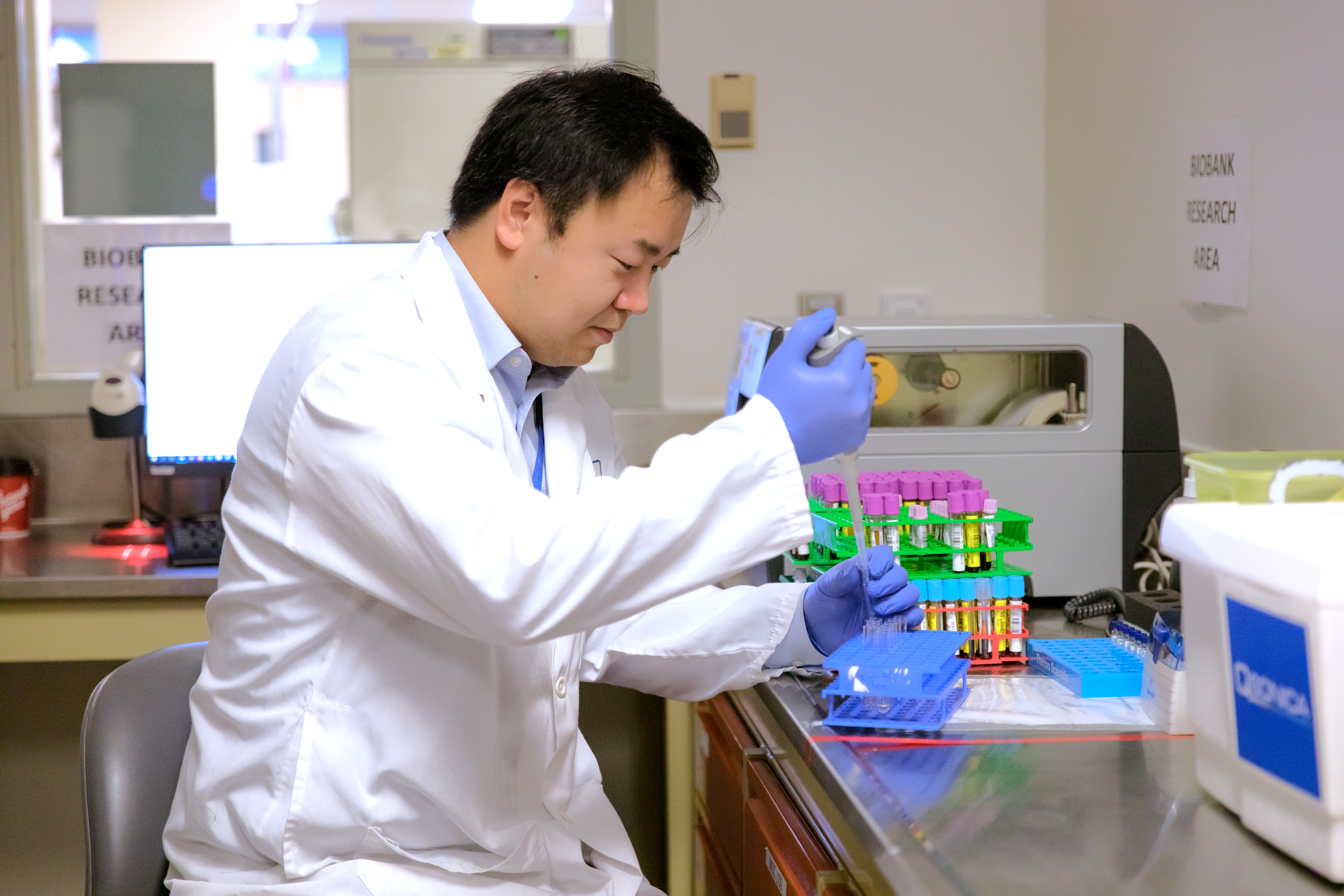 Local Researcher, Dr. Michael Chen, studying blood samples