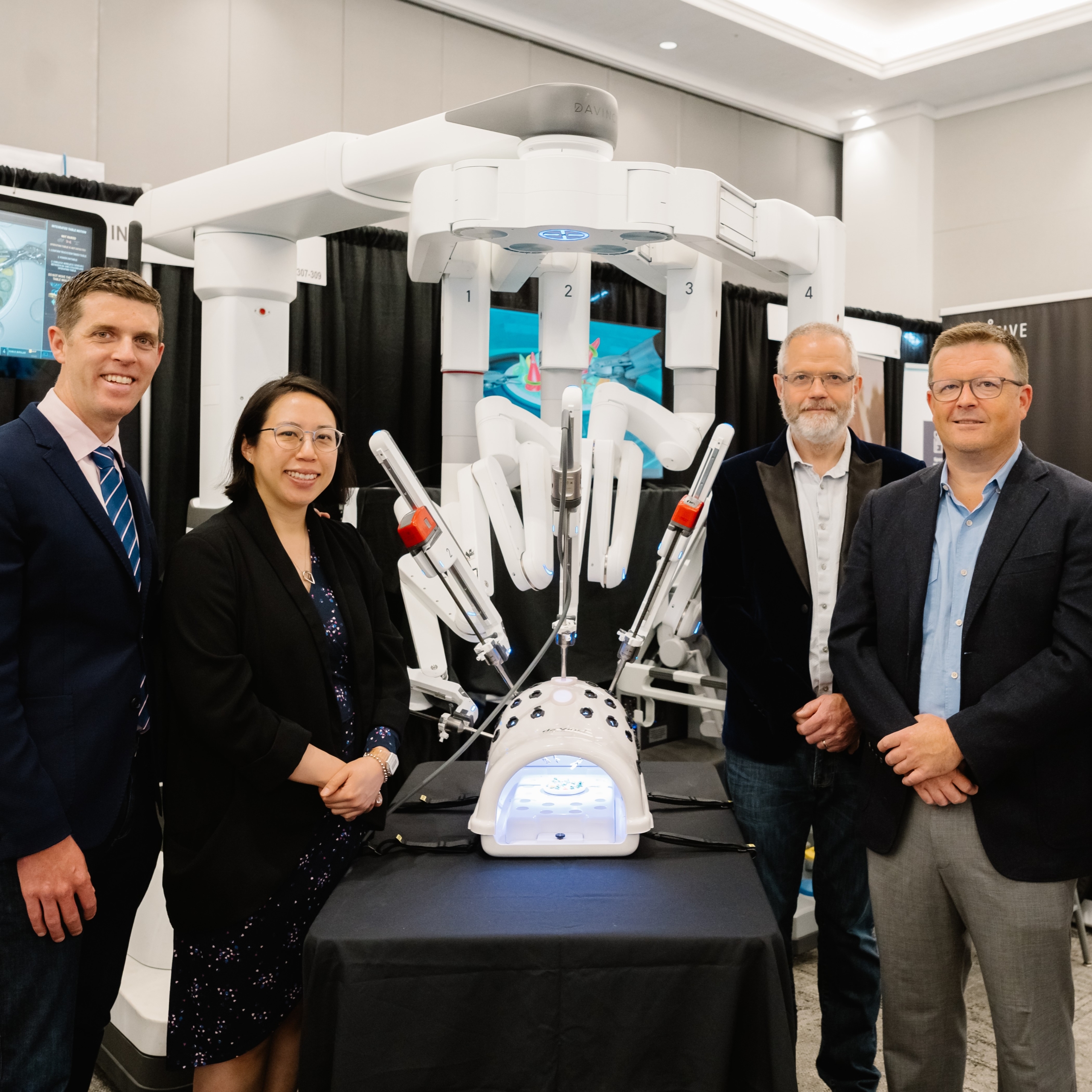Victoria Surgeons standing with a leading-edge surgical robot