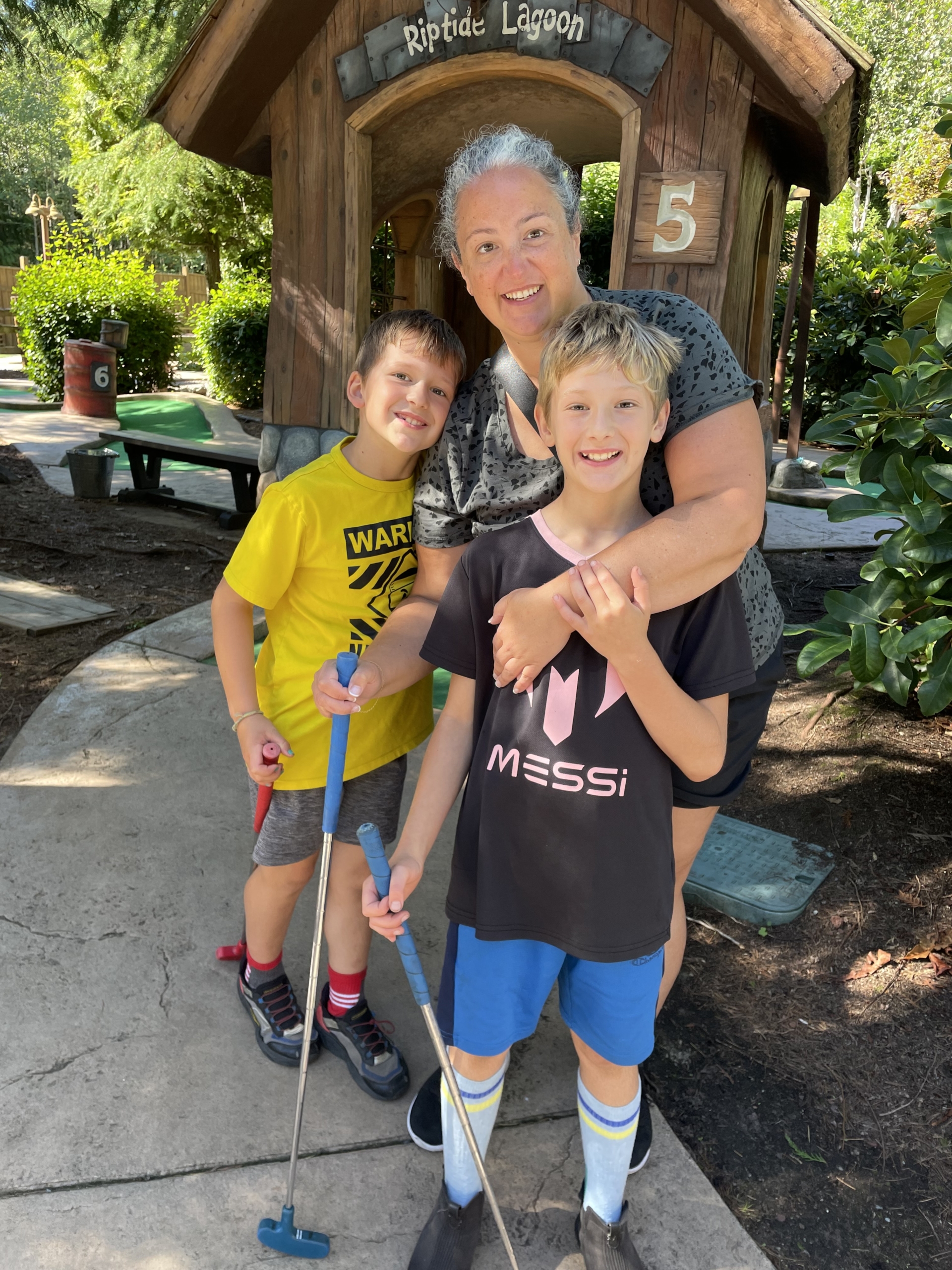 Angela Morehouse, scholarship winner, and her two sons playing minigolf