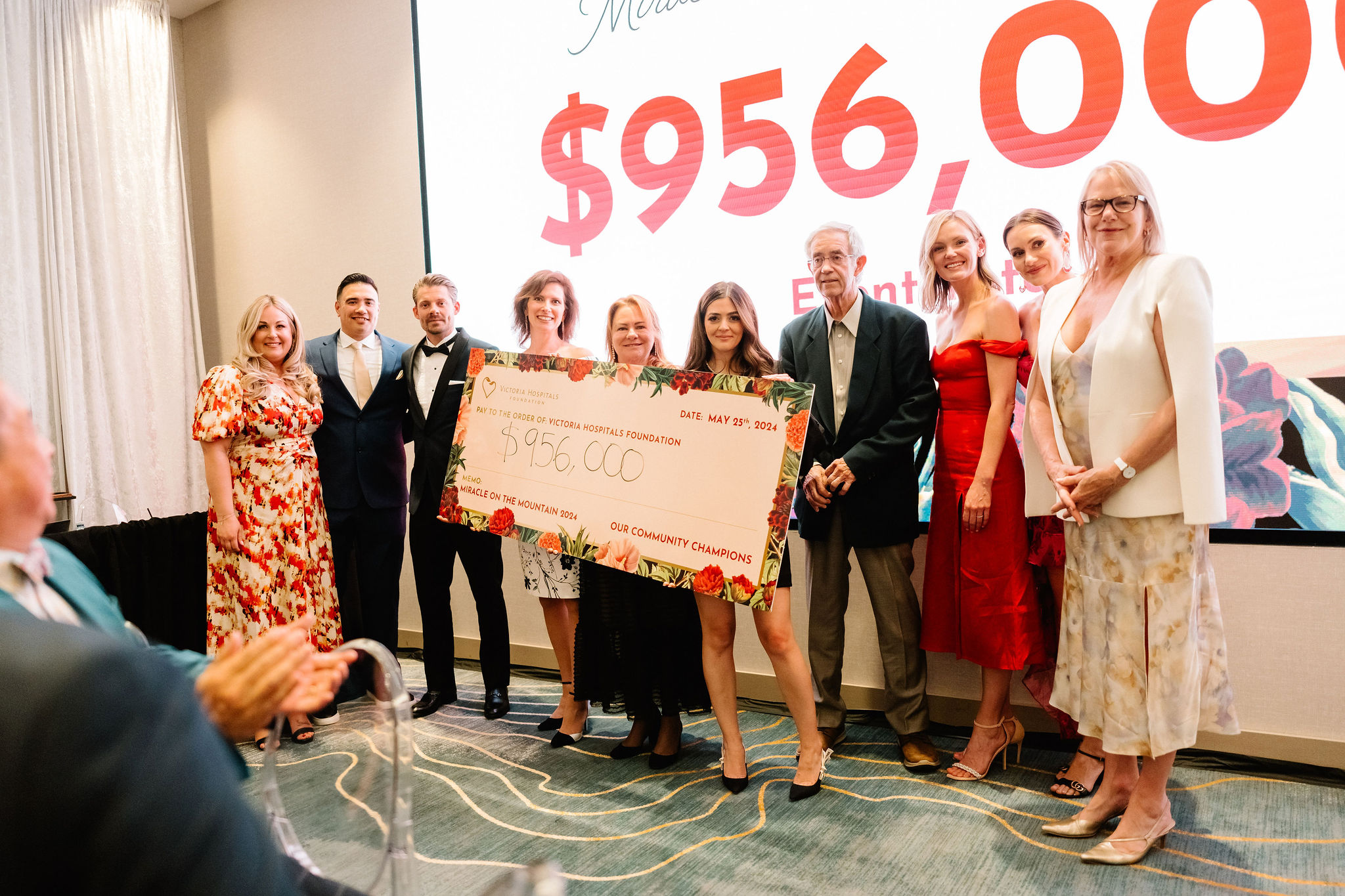 Miracle Gala committee members stand with Victoria Hospitals Foundation CEO Avery Brohman, and Major Donor Craig Mearns, presenting the final total of $956,000 for the 2024 Miracle on the Mountain Gala